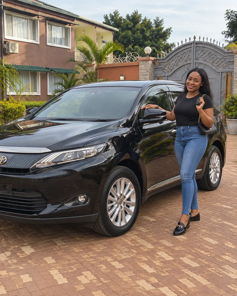 Femme tenant les clés à côté d’un Toyota Harrier noir à Lubumbashi